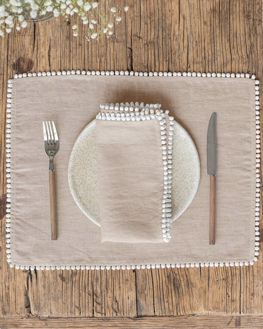 https://cdn.shopify.com/s/files/1/0640/8454/1699/files/pom-pom-trim-linen-napkin-set.jpg?v=1769784328